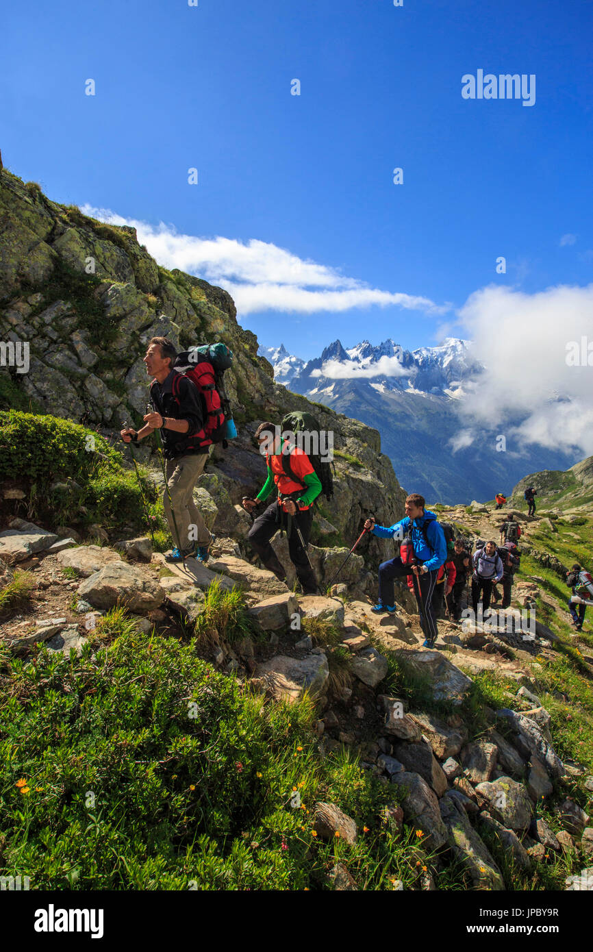 Hikers on the rocky paths around Lac De Cheserys in a sunny summer morning Chamonix Haute Savoie France Europe Stock Photo