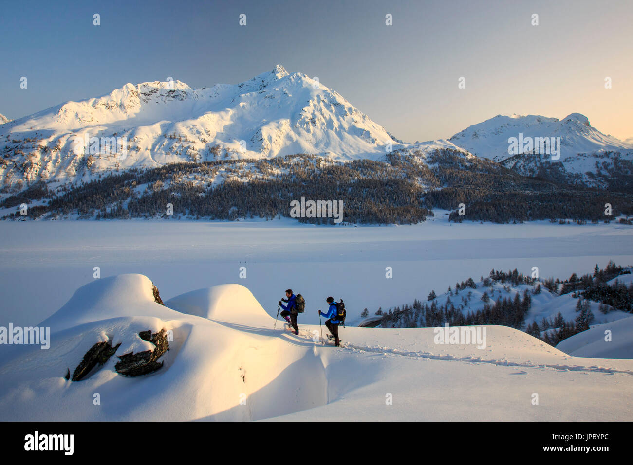 Snowshoe hikers reach a lookout on the Piz de la Margna. Maloja Pass. Engadine. Switzerland. Europe Stock Photo