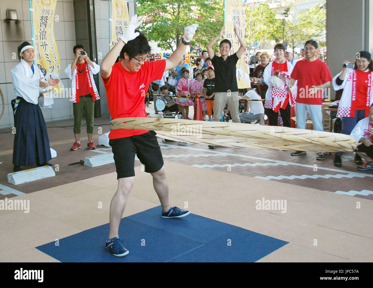 A man rotates a Taga Hoop during an event in Hekinan, Aichi Prefecture in July 2016. Japanese soy sauce and miso fermented soybean paste makers have been holding competitions to hula "taga," or the bamboo hoop used to fasten the wooden barrel that holds the fermented products, in a bid to maintain the condiments' traditional production method. (Kyodo) ==Kyodo Stock Photo