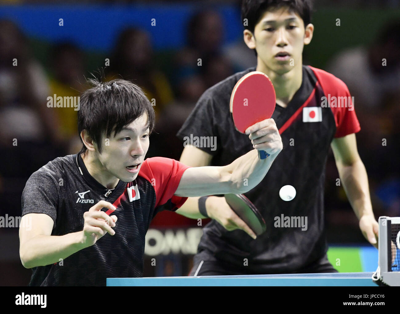 Japan's Koki Niwa (L) and Maharu Yoshimura compete against Wang Zengyi