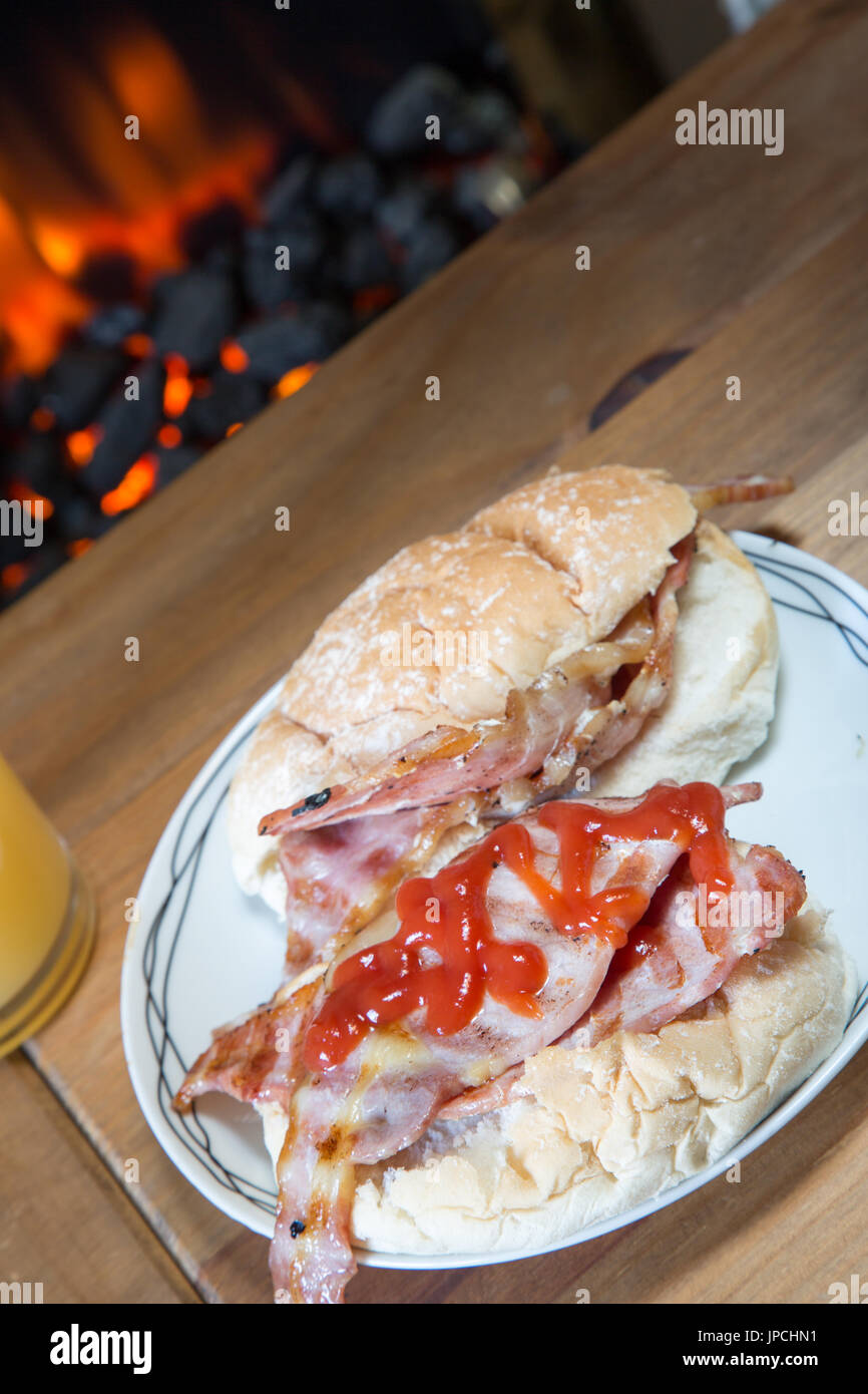 British griddled bacon in a bread roll with ketchup Stock Photo Alamy