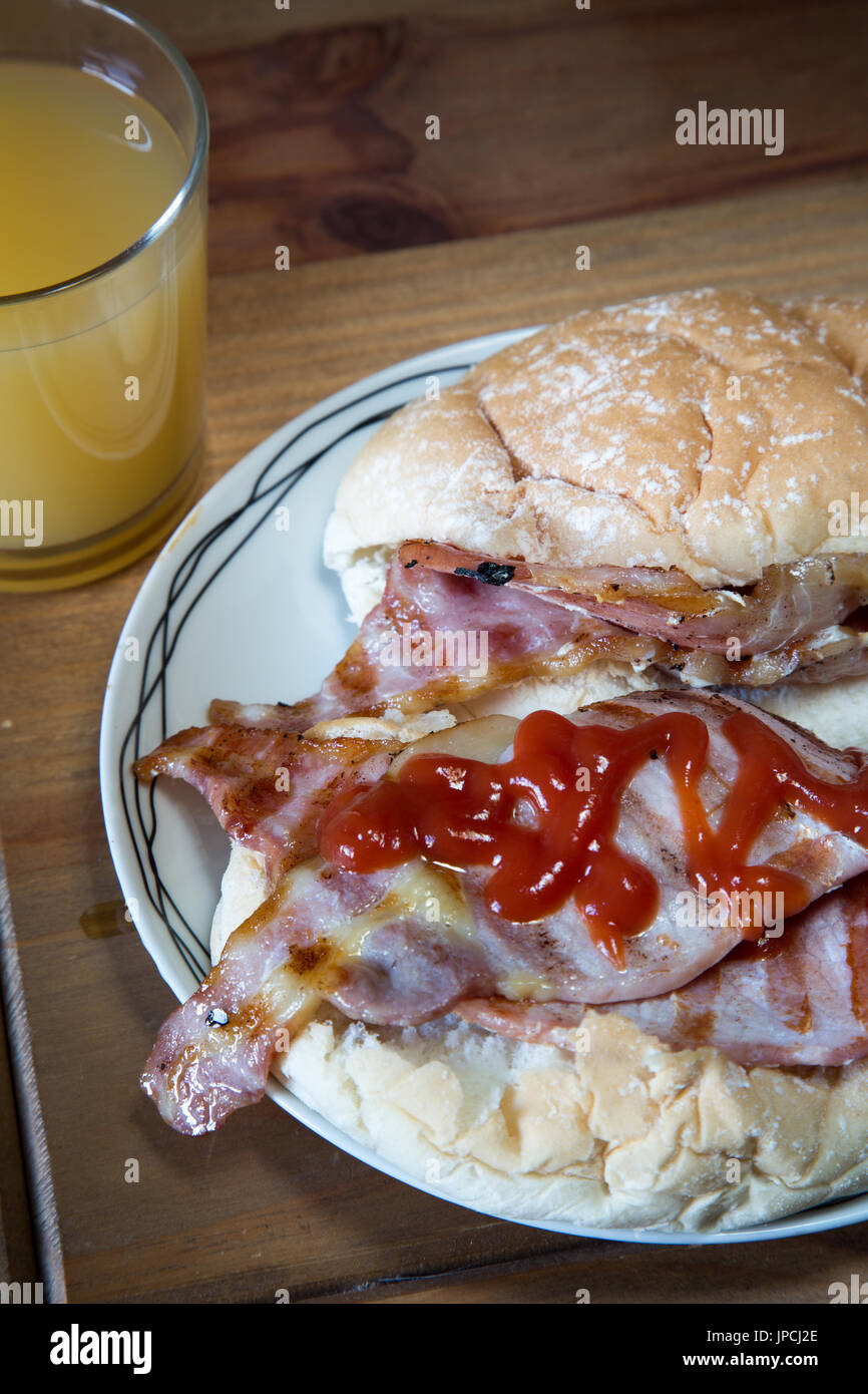 British griddled bacon in a bread roll with ketchup Stock Photo Alamy
