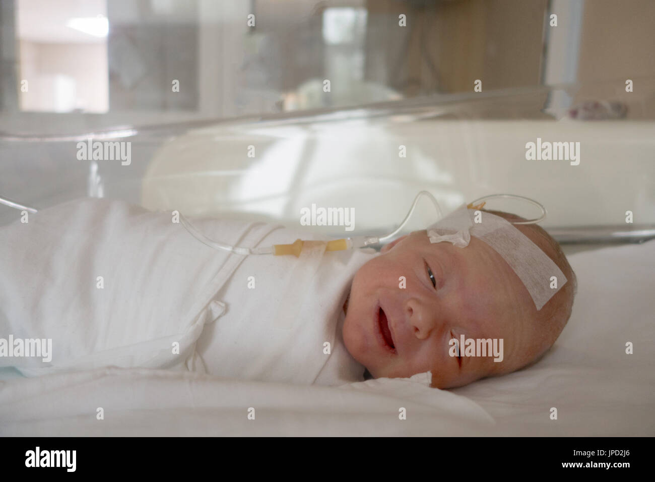 Newborn baby sleeping on a drip in a hospital Stock Photo