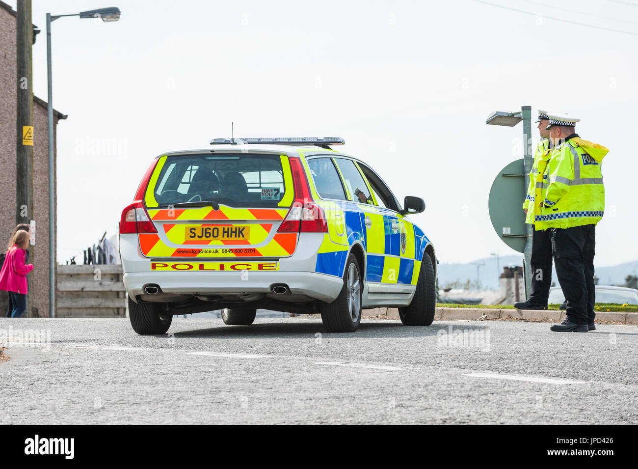 Castle Douglas, Scotland - April 25, 2011: Traffic police officers stand beside a police car that is being used as a road block. The road was closed Stock Photo