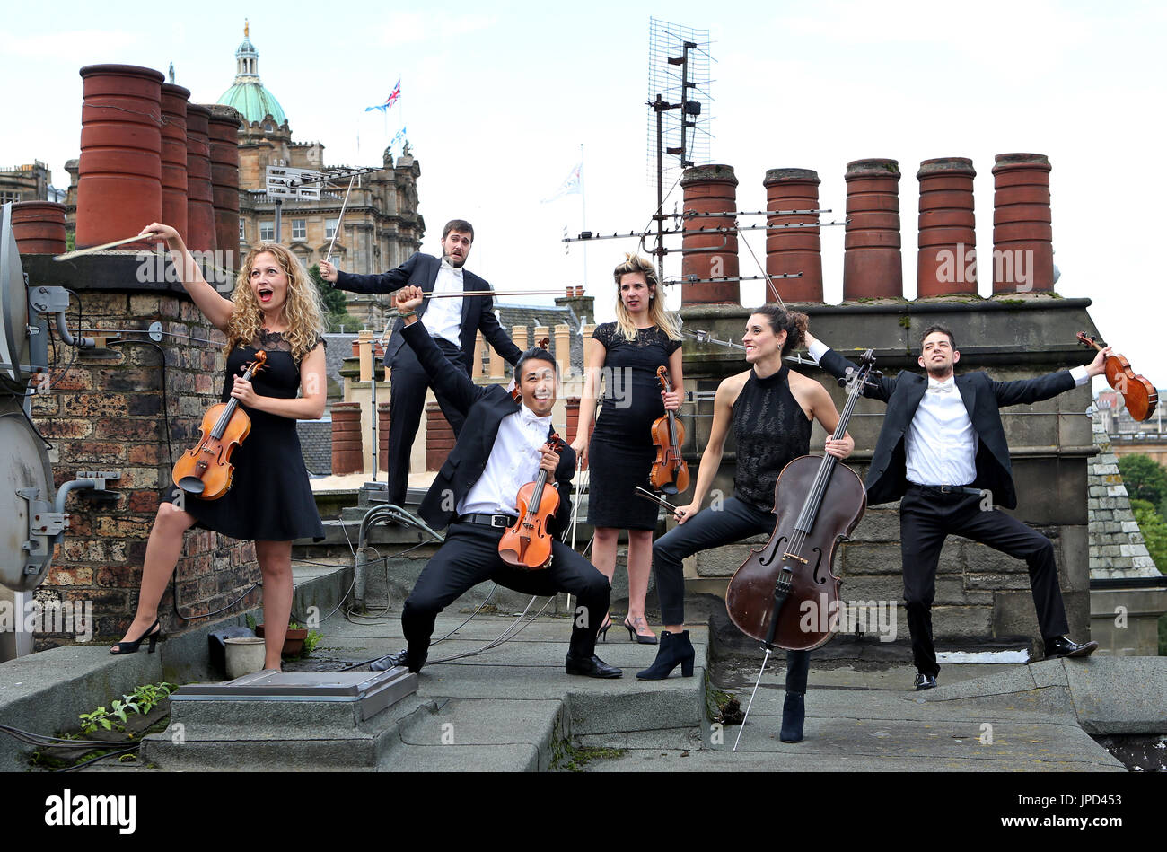 Members of the Catalonian string orchestra Orquestra de Cambra d'emporia perform on the roof tops of Craig's Close in Edinburgh's Old Town ahead of their Edinburgh Festival Fringe show Concerto a Tempo D'Umore. Stock Photo
