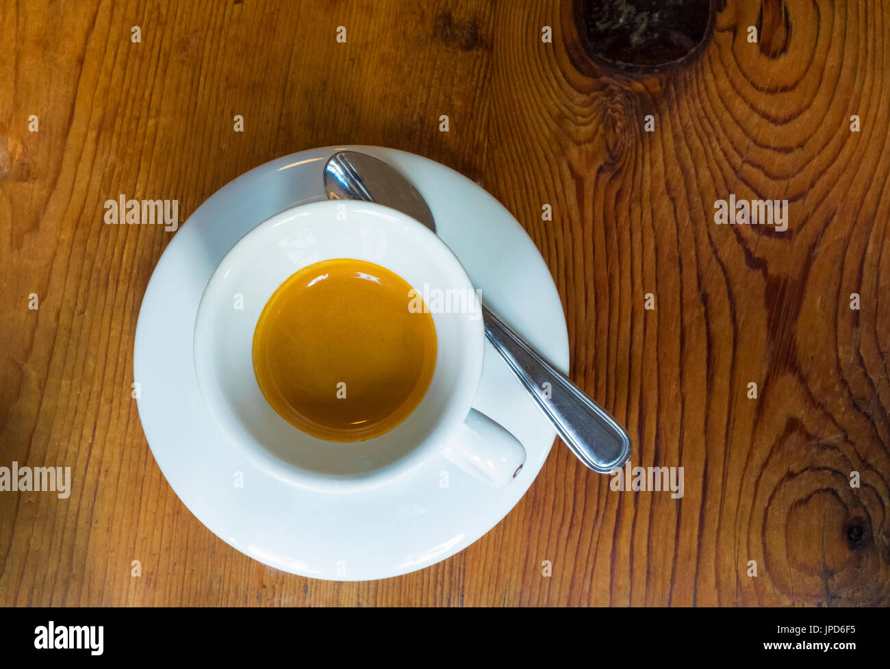 An espresso coffee in a white cup on a wooden table Stock Photo