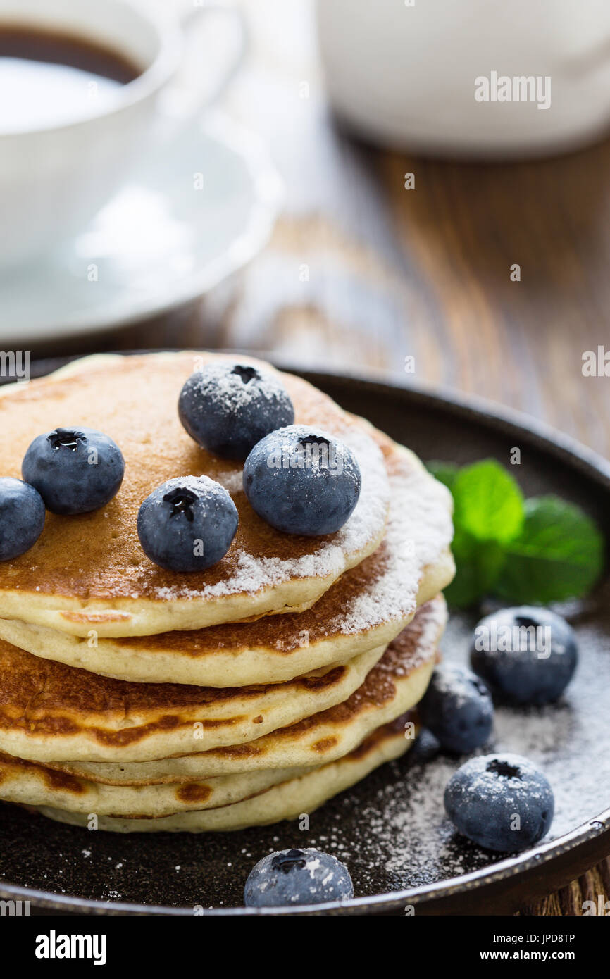 Blueberry buttermilk pancakes in cast iron pan served hot on rustic