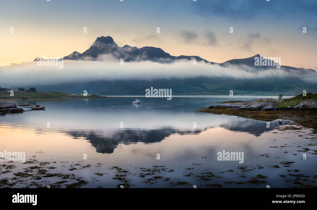 Scenic landscape with mountain reflection and low clouds at summer night in Lofoten, Norway Stock Photo