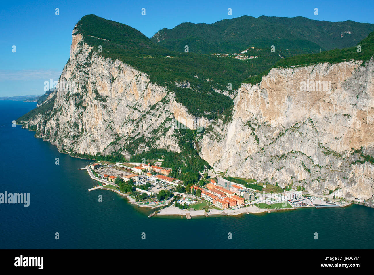 AERIAL VIEW. Village isolated by cliffs more than 400-meter-high, accessible by car through a long tunnel. Campione del Garda, Lombardy, Italy. Stock Photo
