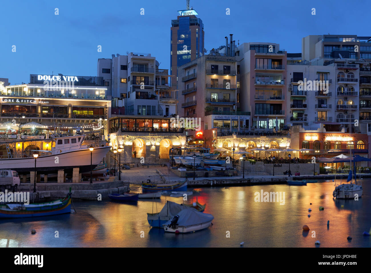 Spinola Bay with terrace taverns and Portomaso Tower, evening atmosphere, St. Julian's, Malta Stock Photo
