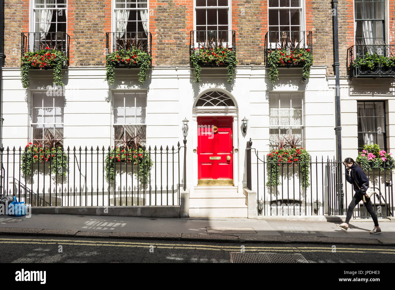 A woman walking past Georgian housing on Craven Street in London, WC2, UK Stock Photo