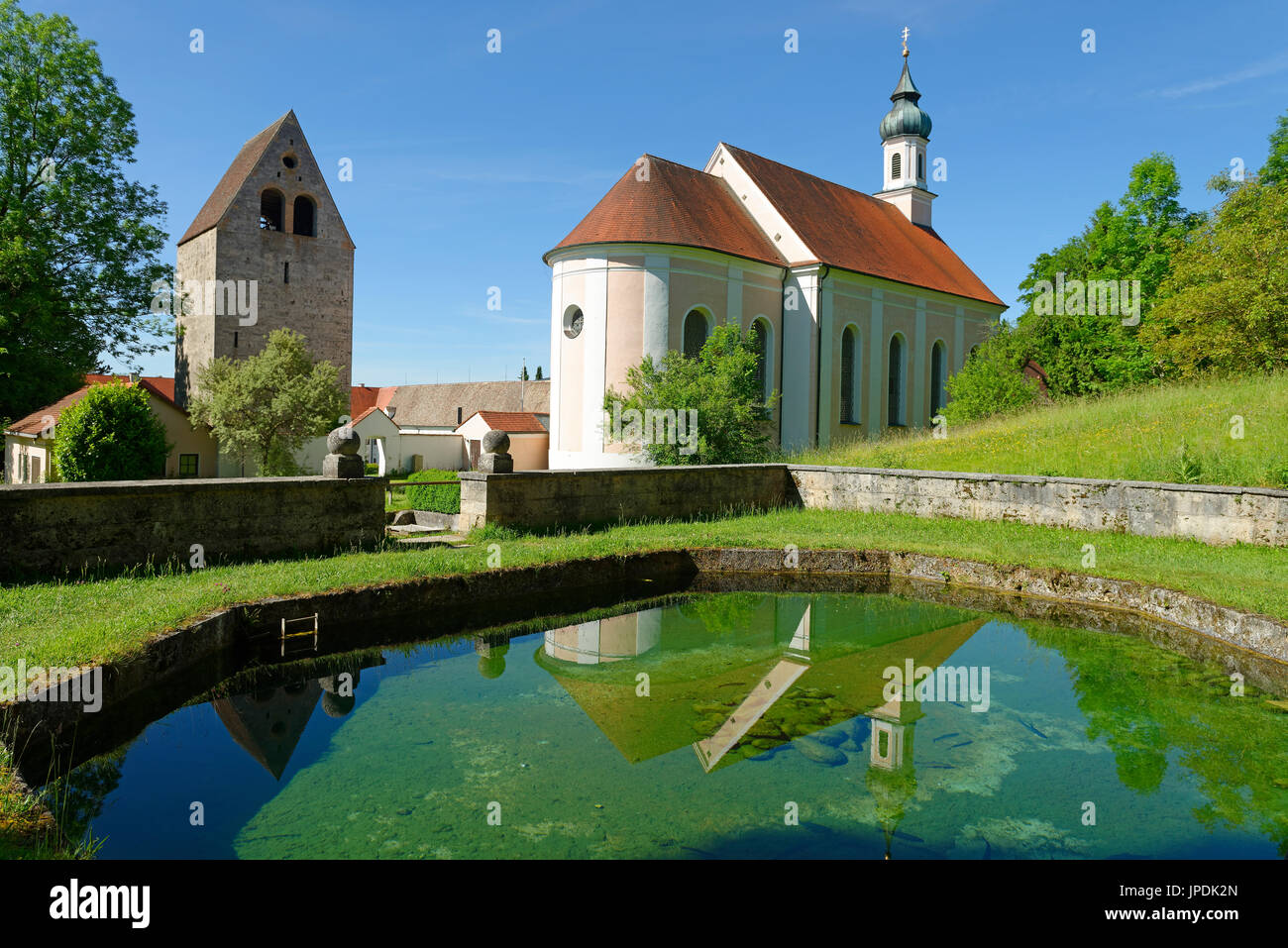 Historisches Brunnenhaus mit der Pfarrkirche St. Johannes Baptist und Glockenturm des ehemaligen Klosters, Grauer Herzog,  Wessobrunn im Pfaffenwinkel Stock Photo