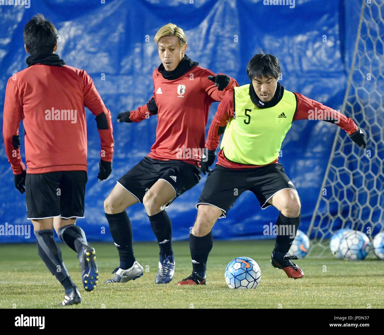 Keisuke Honda (C) and Shinji Okazaki (R) vie for the ball during
