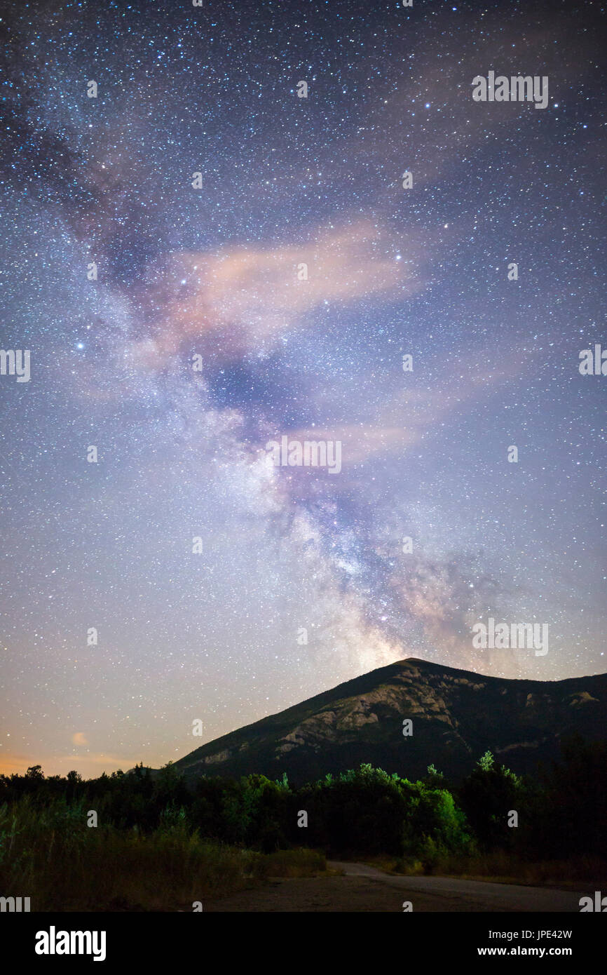 A view of the stars of the Milky Way with a mountain top in the foreground. Night sky nature summer landscape. Perseid Meteor Shower observation. Rtan Stock Photo
