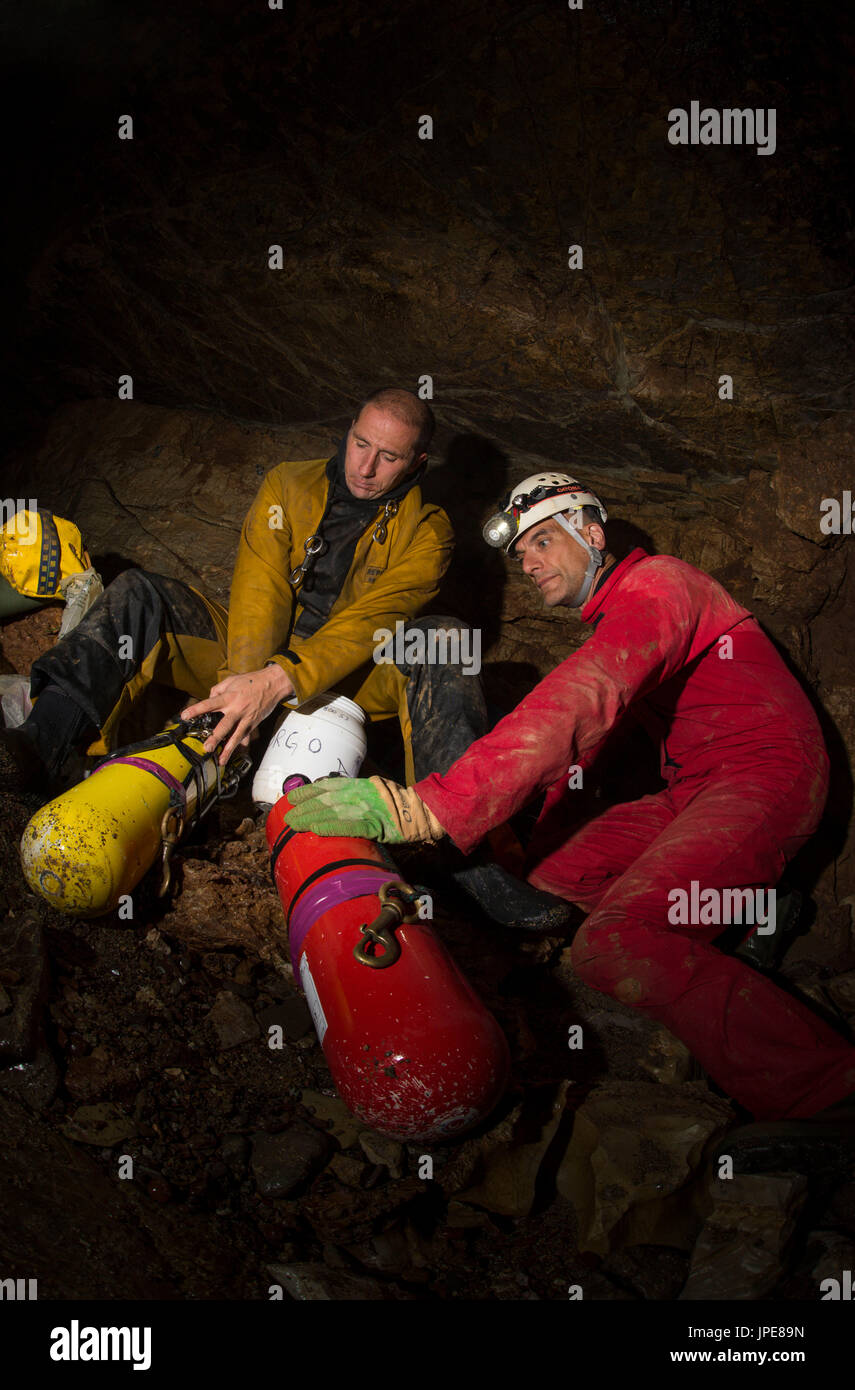 Diving on a cave, Liguria, Italy, Europe. Cave scuba diver preparing equipment with his swimfins and diving cylinders. Stock Photo