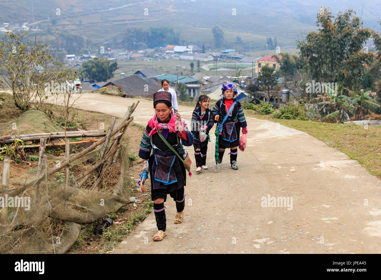 Aboriginal people of the mountains of Sapa, in north Vietnam, dressed with their traditional attire and walking in their village Stock Photo