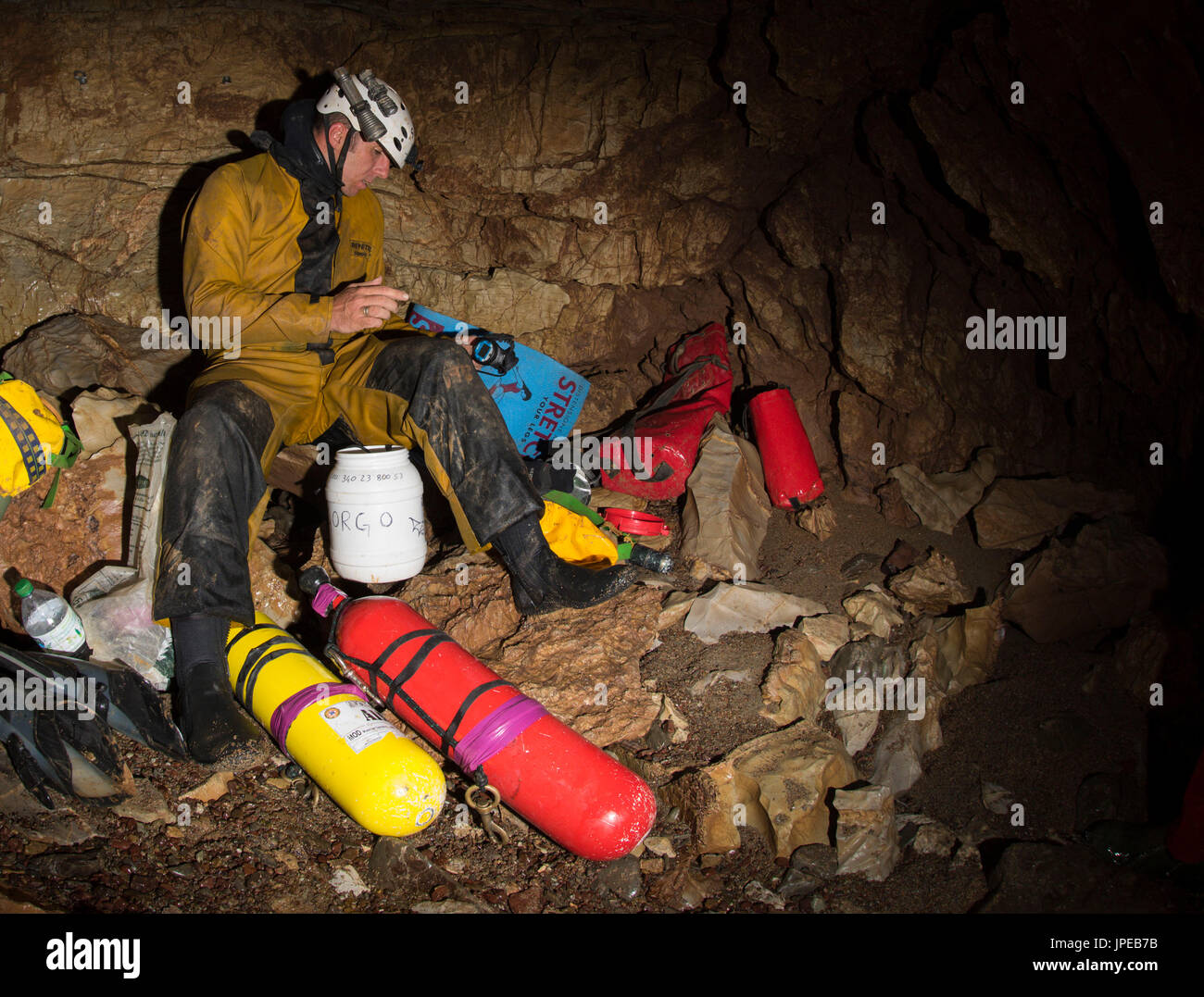 Diving on a cave, Liguria, Italy, Europe. Cave scuba diver preparing equipment with his swimfins and diving cylinders. Stock Photo