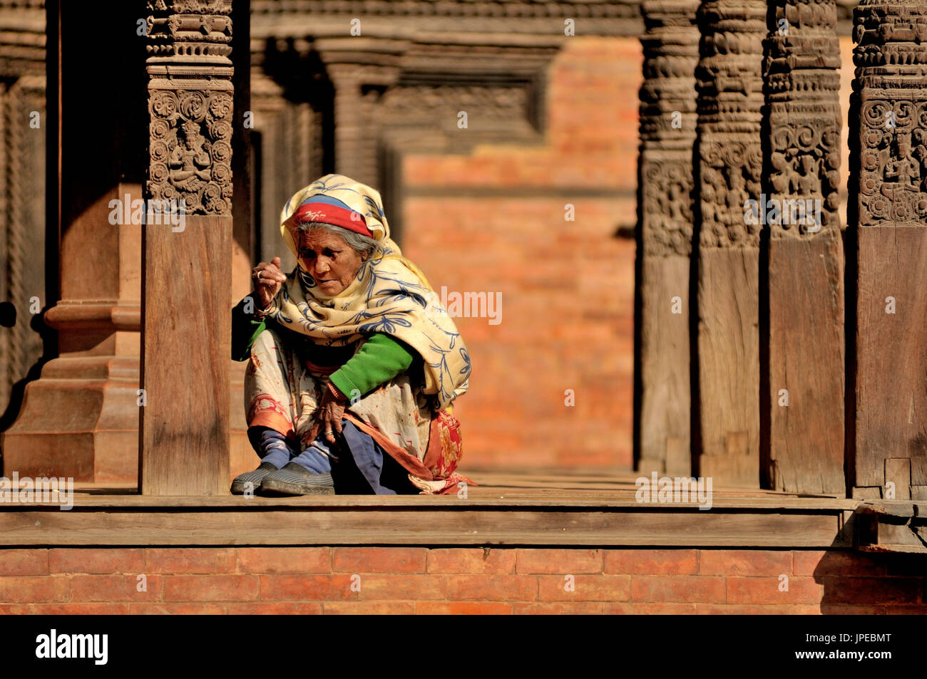 Nepal woman, resting in the square between the temples of Durbar Sq in Bhaktapur, Nepal Stock Photo