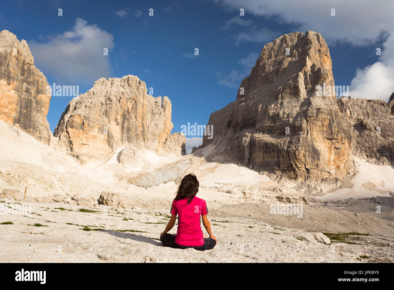a new age image of a woman sitting in meditation in front of the moon with Brenta Group in the background, Trento province, Trentino Alto Adige, Italy, Europe Stock Photo