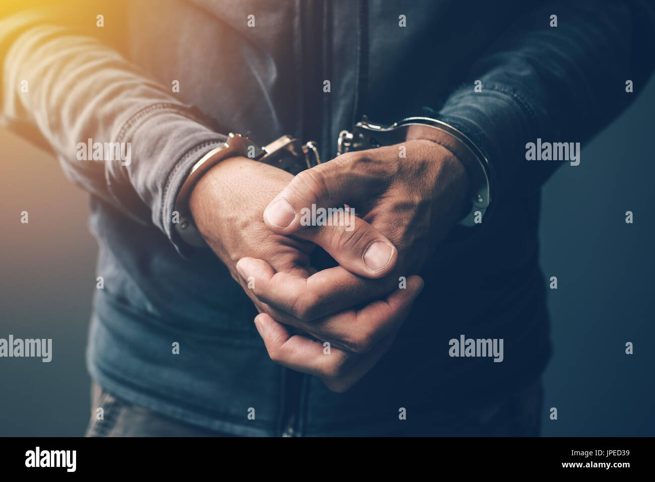 Arrested computer hacker and cyber criminal with handcuffs, close up of hands Stock Photo