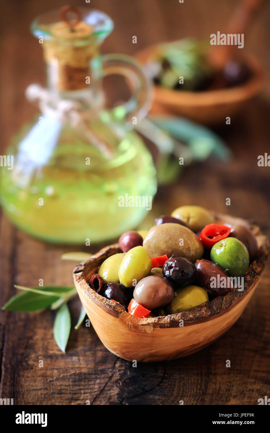 Olives a la Provencale. Provencal style mixed pitted olives on dark rustic wooden background Stock Photo