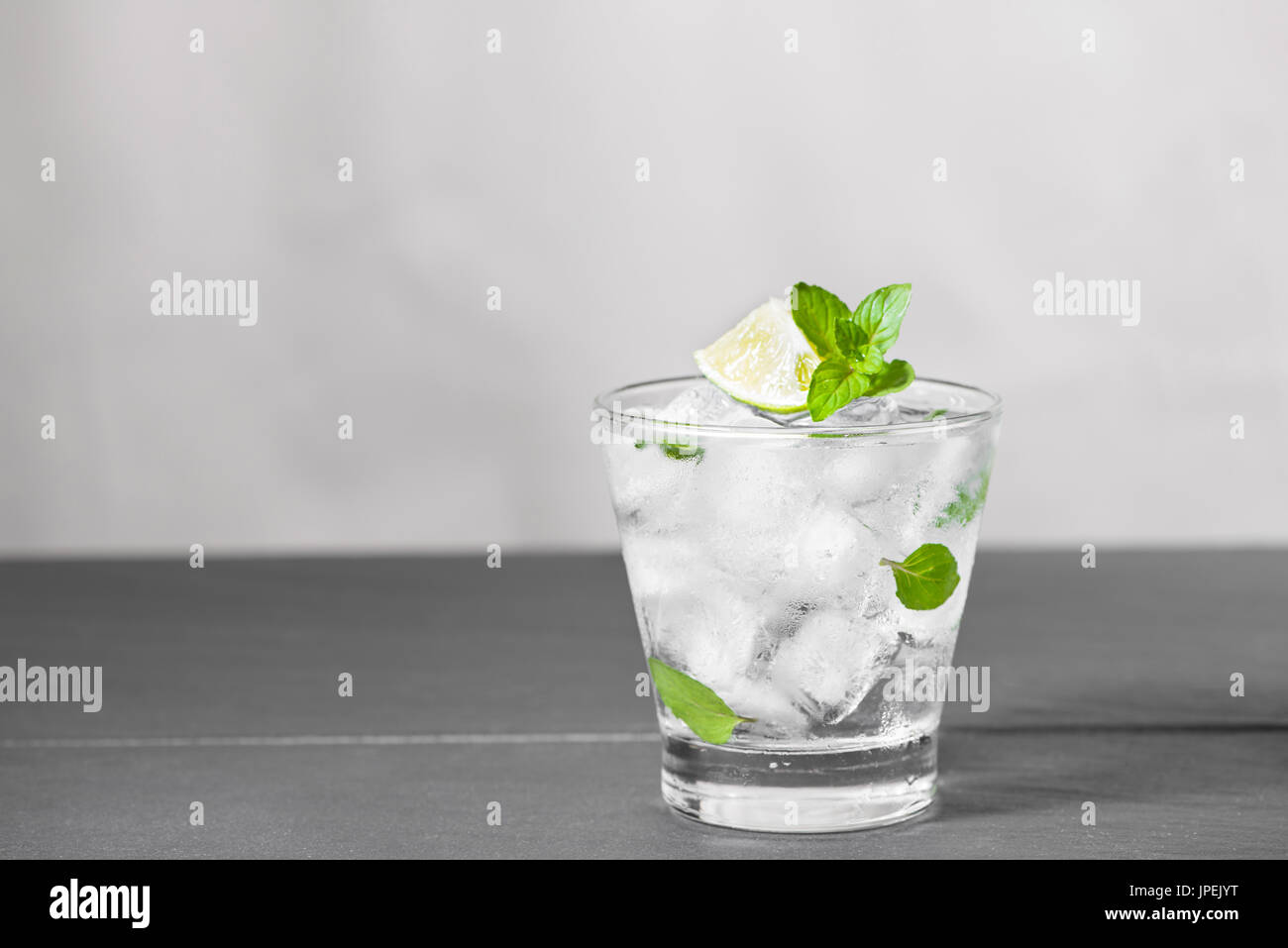 https://c8.alamy.com/comp/JPEJYT/mojito-cocktail-with-lime-and-mint-in-glass-on-a-grey-stone-background-JPEJYT.jpg