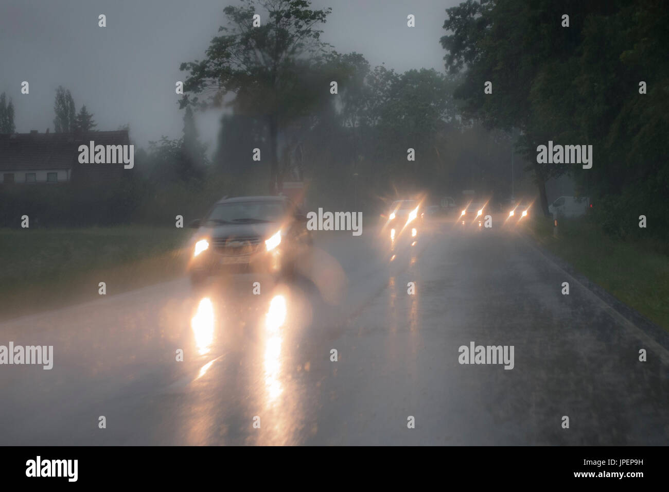 Gefährliche Autofahrt bei Starkregen, blendende Scheinwerfer im Gegenverkehr Stock Photo