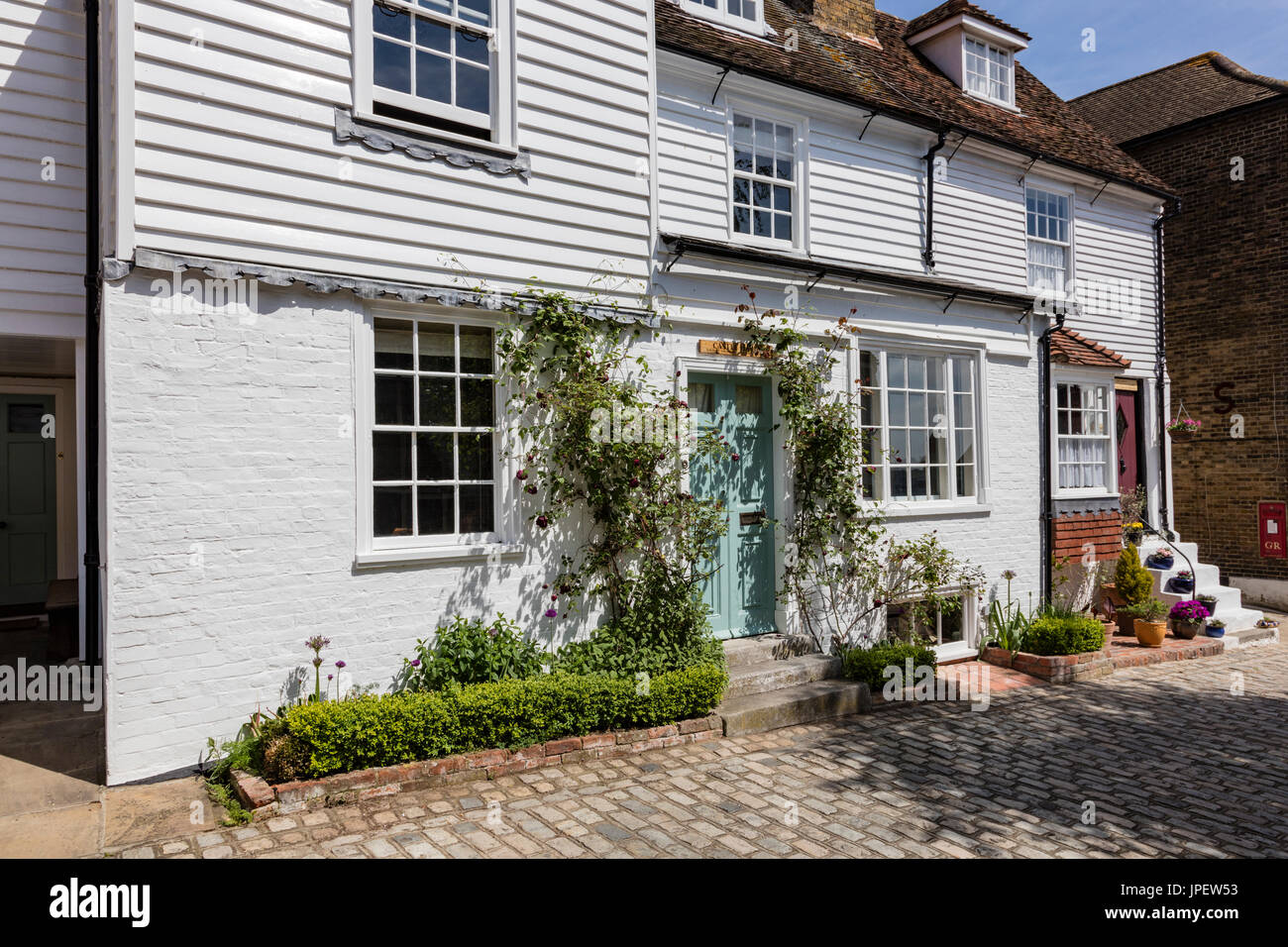 An attractive weatherboarded cottage on the cobbled Upnor High Street, converted from a former pub, Kent, UK Stock Photo
