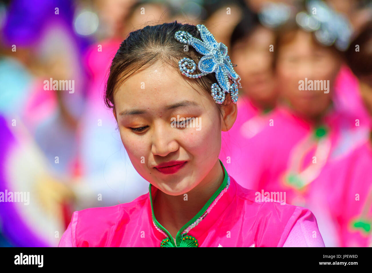 Female performer with colorful costume and fascinator in the parade on