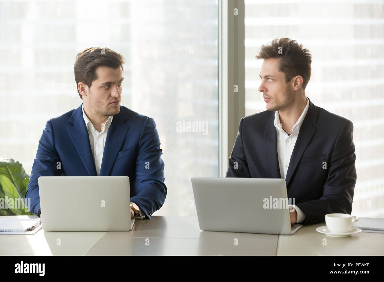 Two confident businessmen dislike each other, business competiti Stock Photo