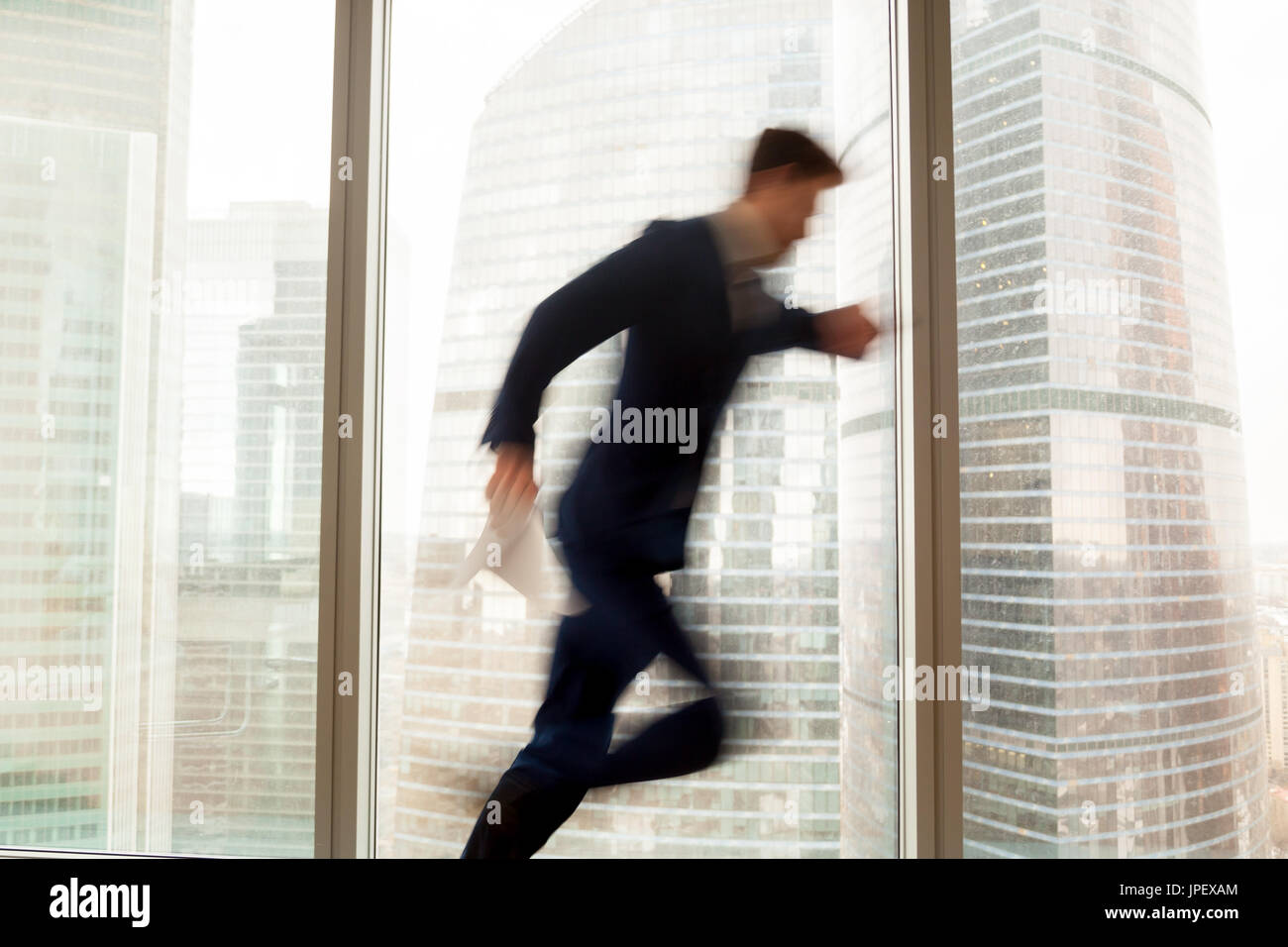 Busy businessman hurrying up, getting late, city view, motion bl Stock Photo