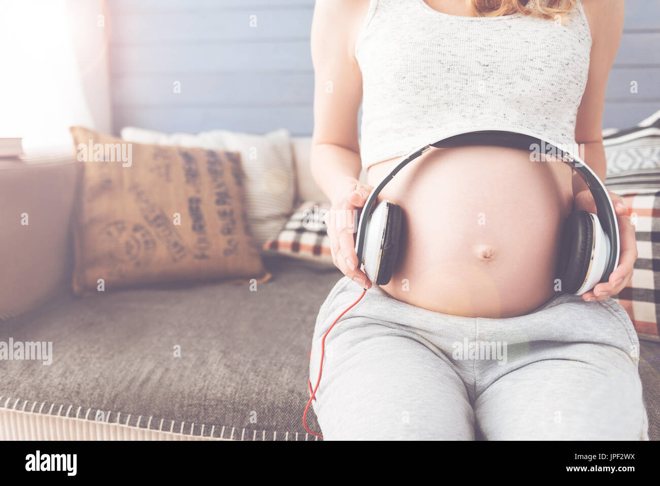 Pregnant young mother listening to music Stock Photo