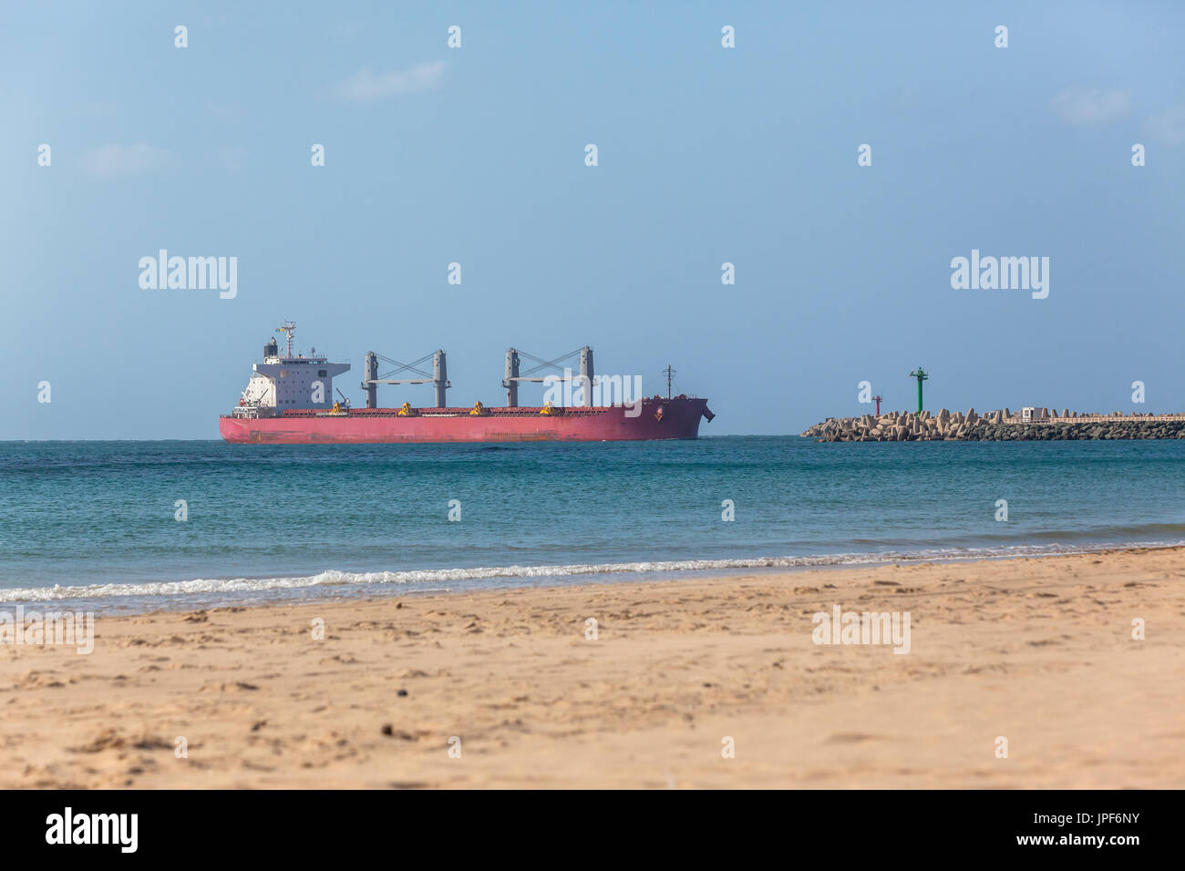 Ocean ship enters port between two pier beacons Stock Photo