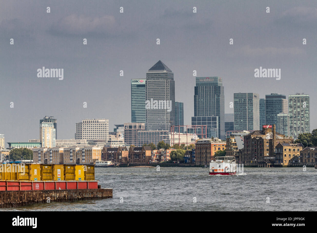 The Skyscrapers of Canary Wharf tower over The River Thames as seen from the riverbank in Bermondsey, London Stock Photo