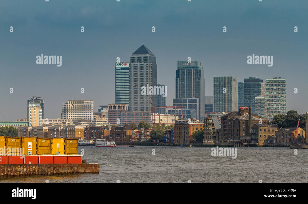 The Skyscrapers of Canary Wharf tower over The River Thames as seen from the riverbank in Bermondsey, London Stock Photo