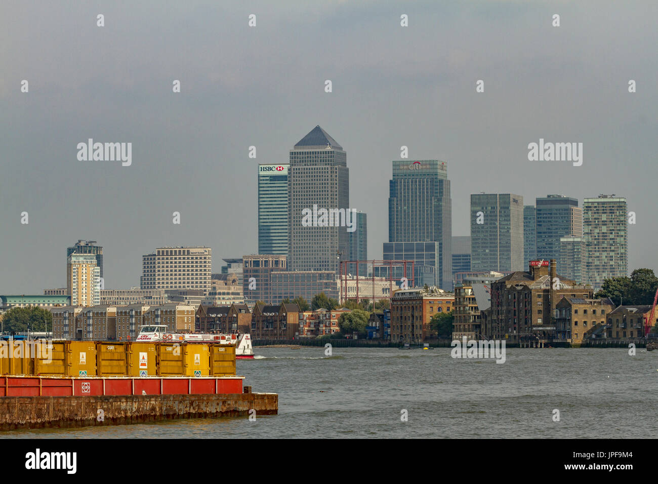 The Skyscrapers of Canary Wharf tower over The River Thames as seen from the riverbank in Bermondsey, London Stock Photo