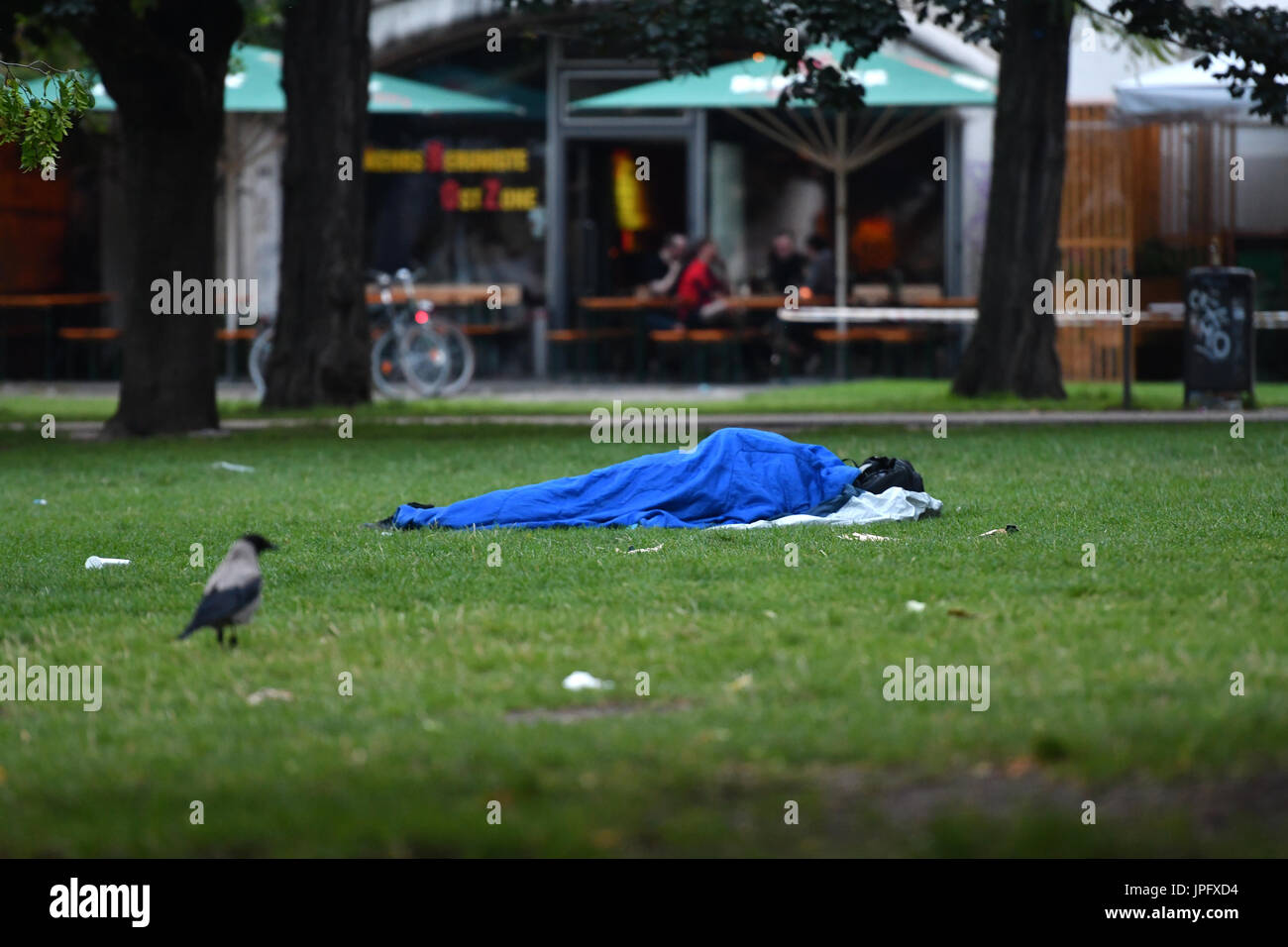 Berlin, Germany. 02nd Aug, 2017. A man lying on the grass and sleeping at the James Simon Park in Berlin, Germany, in the morning of 02 Augustr 2017. Photo: Paul Zinken/dpa/Alamy Live News Stock Photo