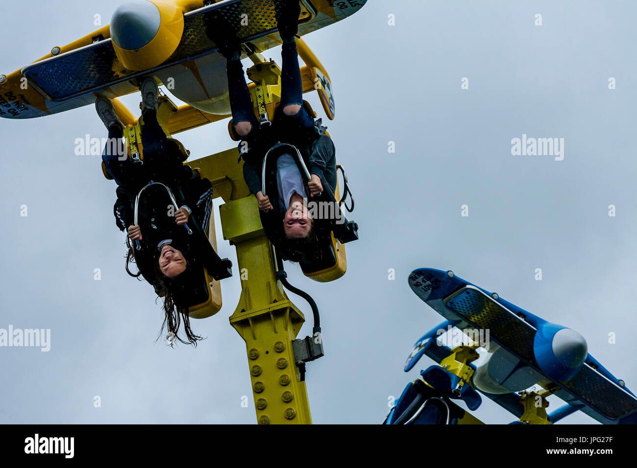 Brighton, UK. 2nd Aug, 2017. UK Weather. Two young women having fun on a fairground ride in the rain, Brighton Pier, Brighton, East Sussex, UK. Credit: Grant Rooney/Alamy Live News Stock Photo