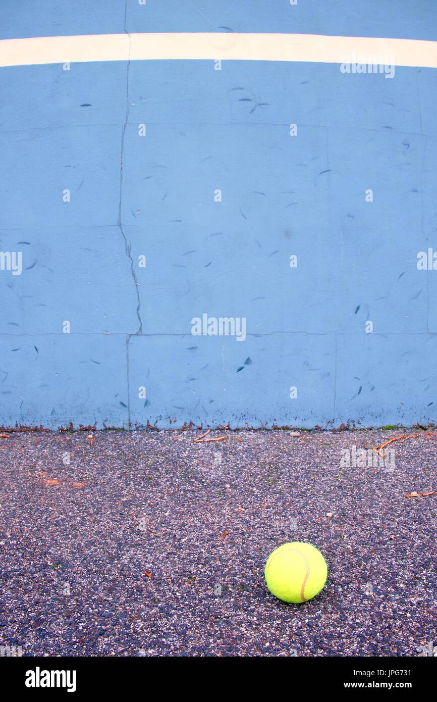 Ball beside tennis training wall. Empty training tennis court, end of