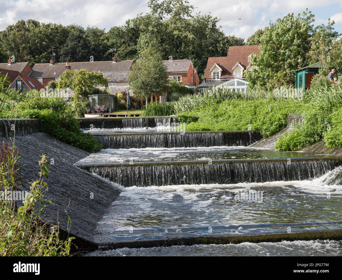 Silt-laden water rushing over a weir on the River Stour Blandford Dorset  England UK Stock Photo - Alamy