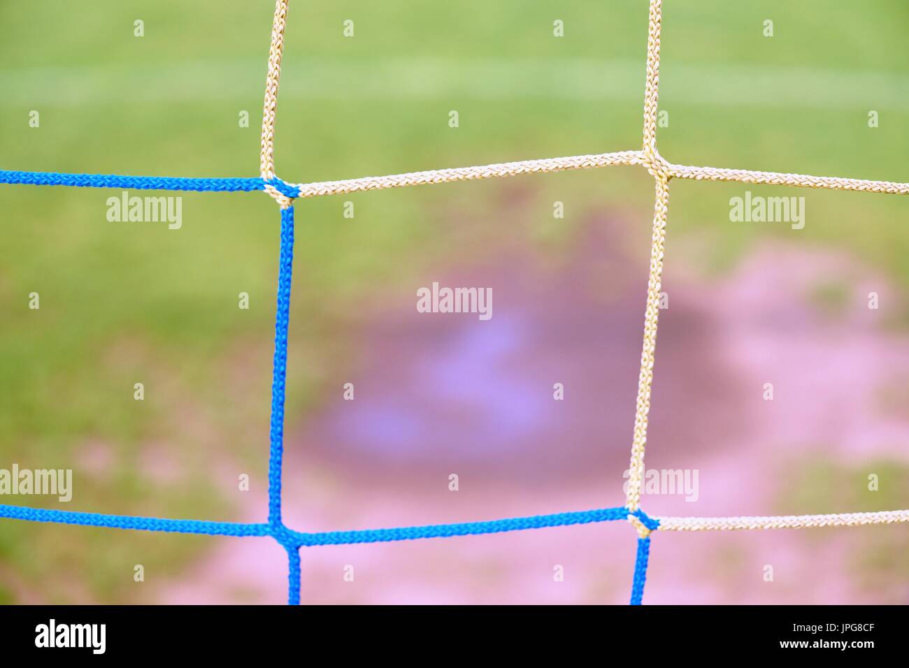 View through football gate to water and mude in poor soccer field