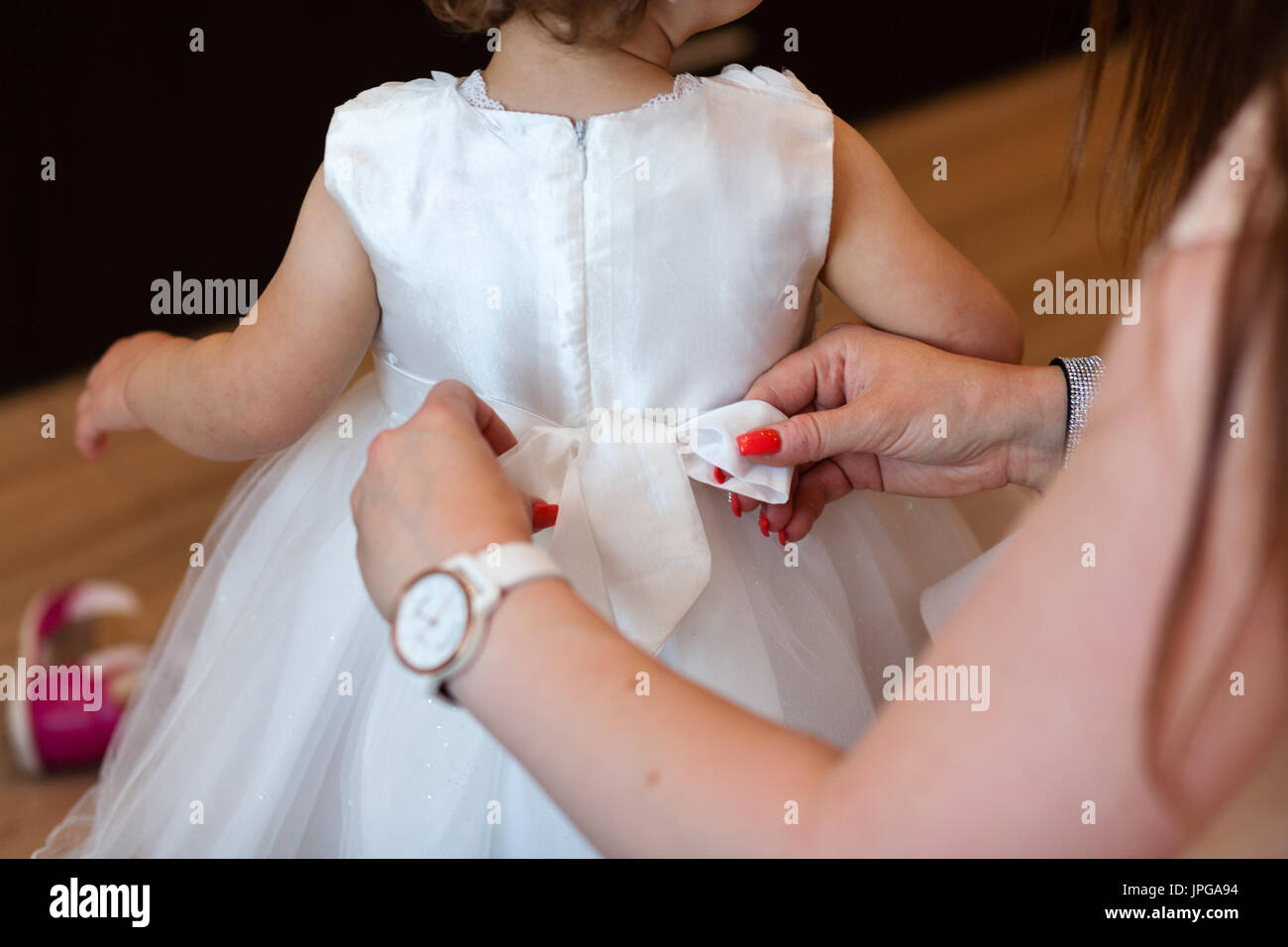 Baby prepared by mother with white ceremonial clothes. Baptism clothes