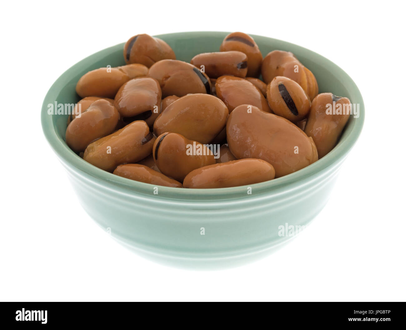 A serving of canned fava beans in a small green bowl isolated on a