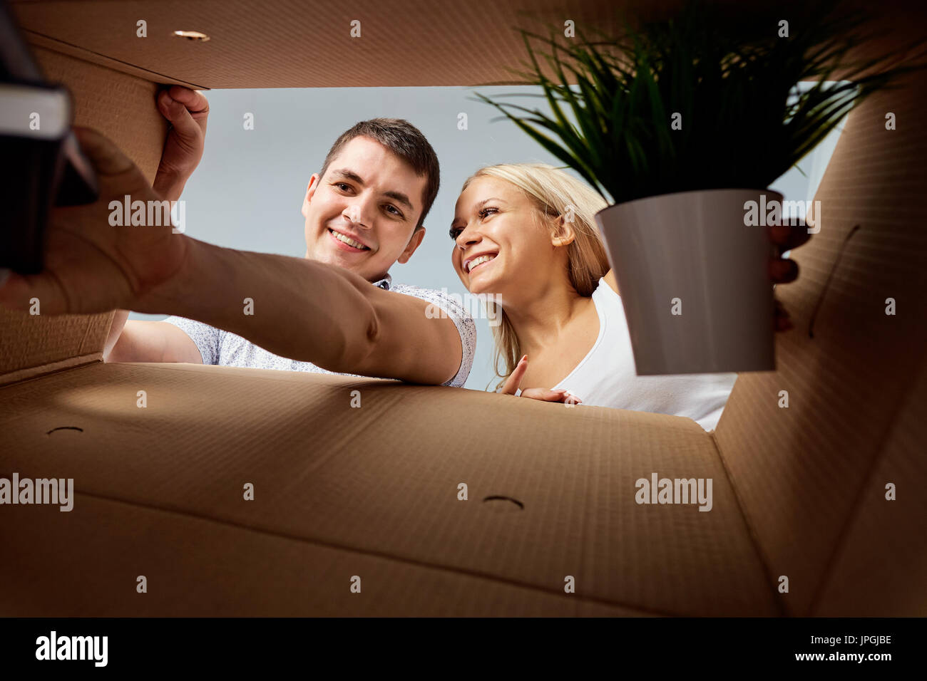 A young couple unpacks boxes. Stock Photo