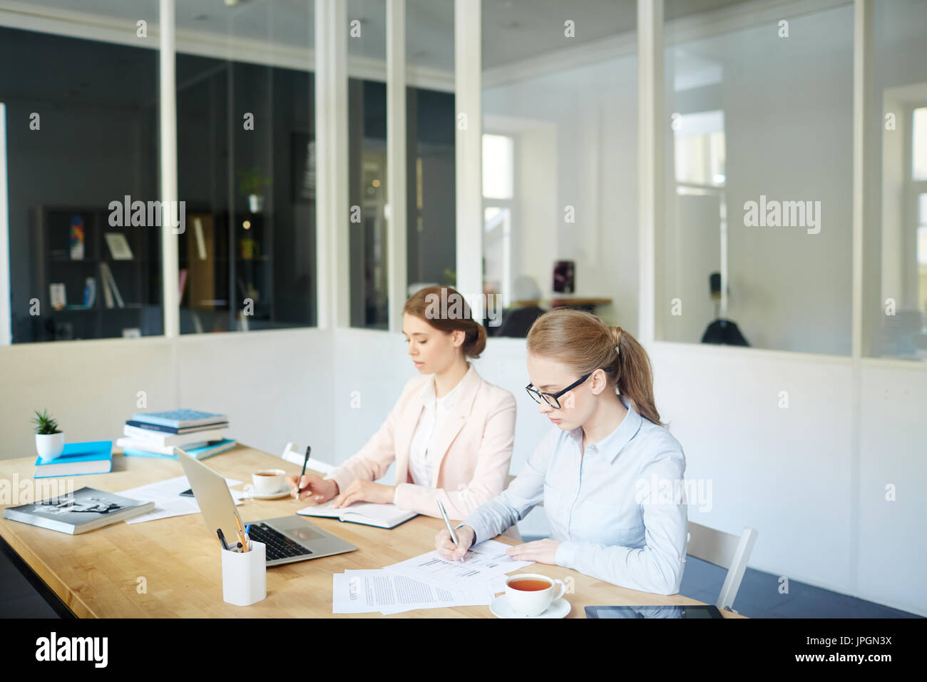 Young economists carrying out written task Stock Photo