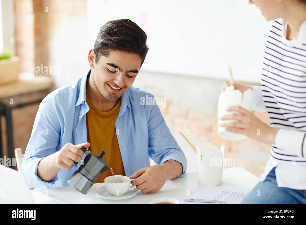 Young colleagues having lunch break at workplace Stock Photo