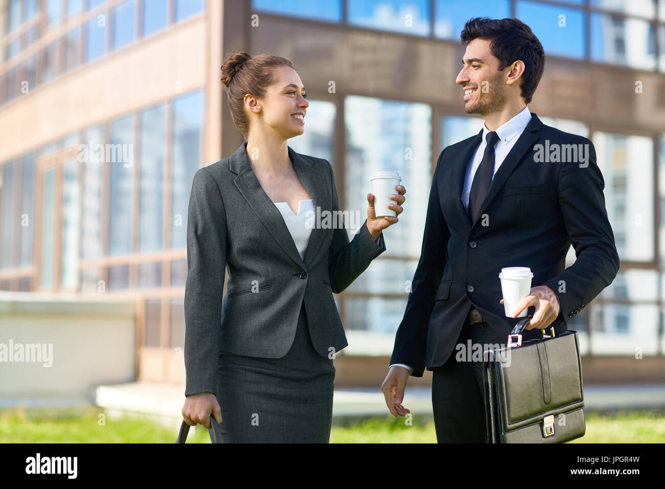 Two young entrepreneurs having talk while walking in the city Stock Photo