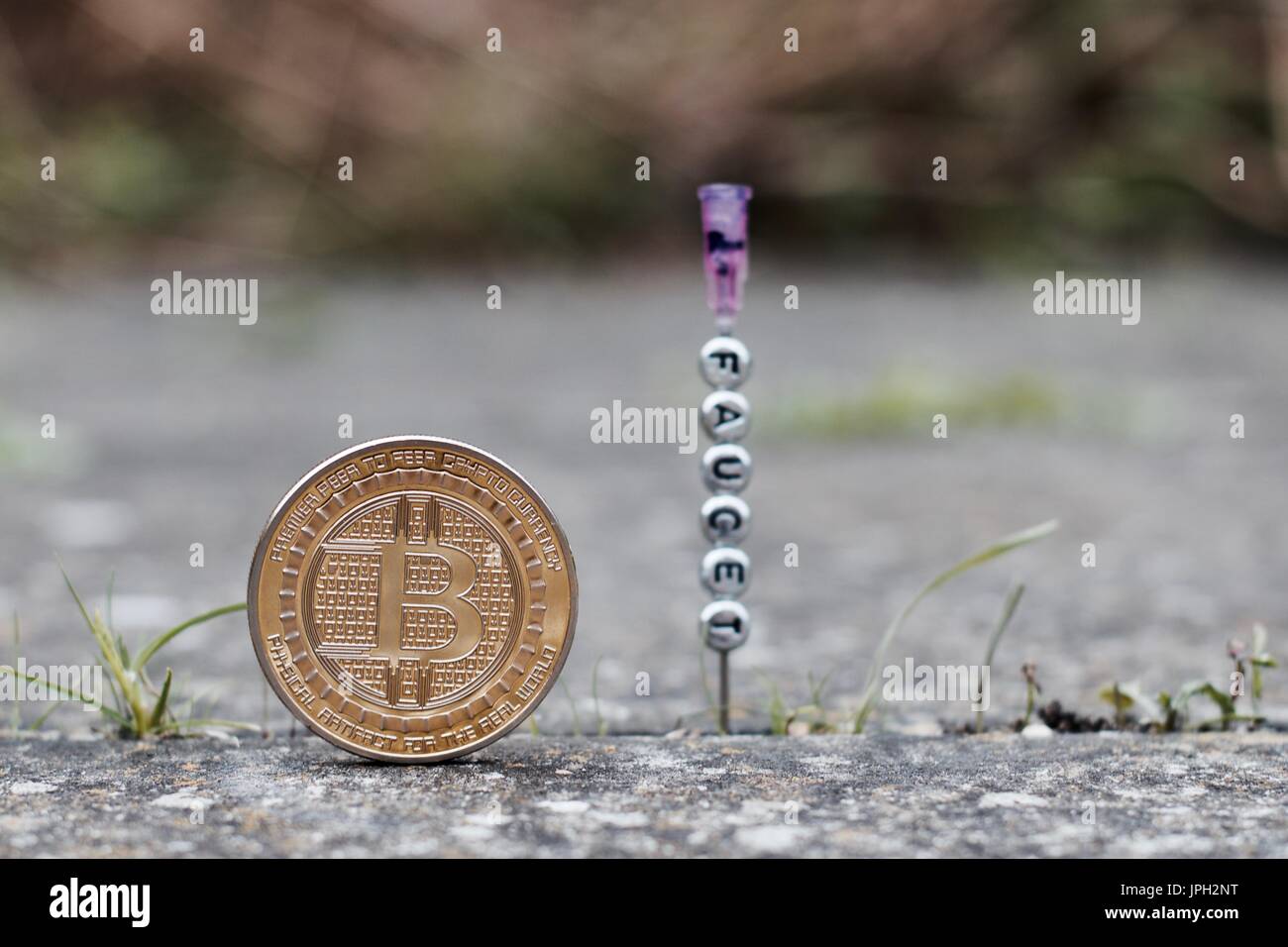 Digital currency physical gold bitcoin coin near faucet inscription on the  needle Stock Photo - Alamy