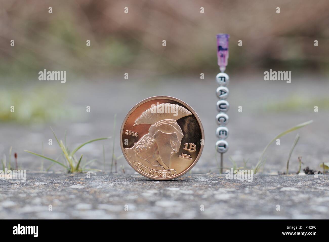 Digital currency physical gold titan bitcoin coin with qr code near faucet  on the needle Stock Photo - Alamy