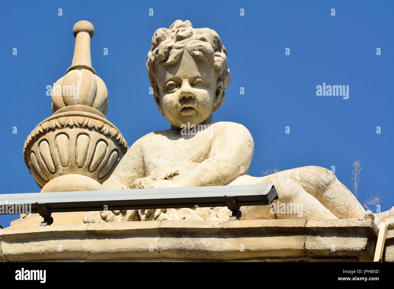 Sculpture of angel boy on facade of architectural building in downtown Baku. Stock Photo